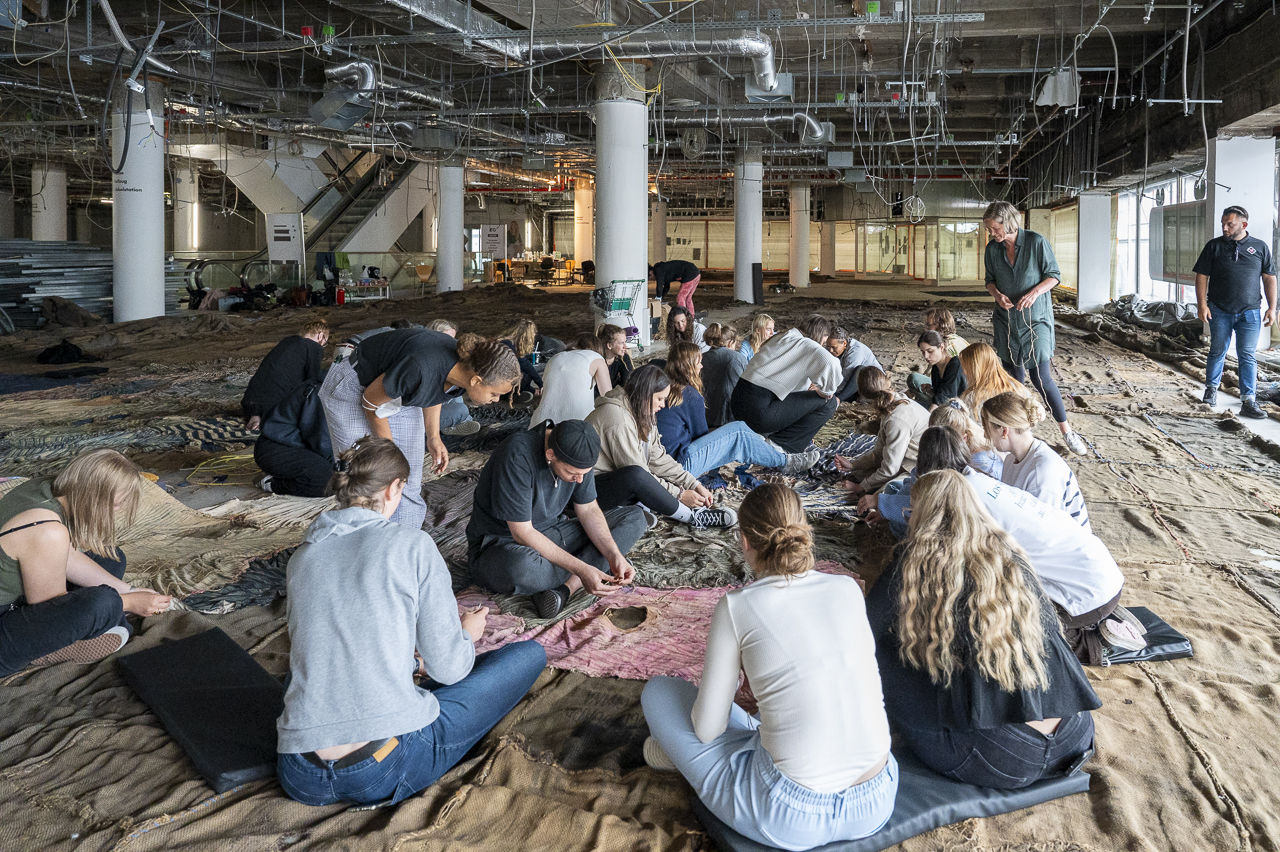 Volunteers and team members sewing the fabrics together inside the former Galeria Kaufhof building.